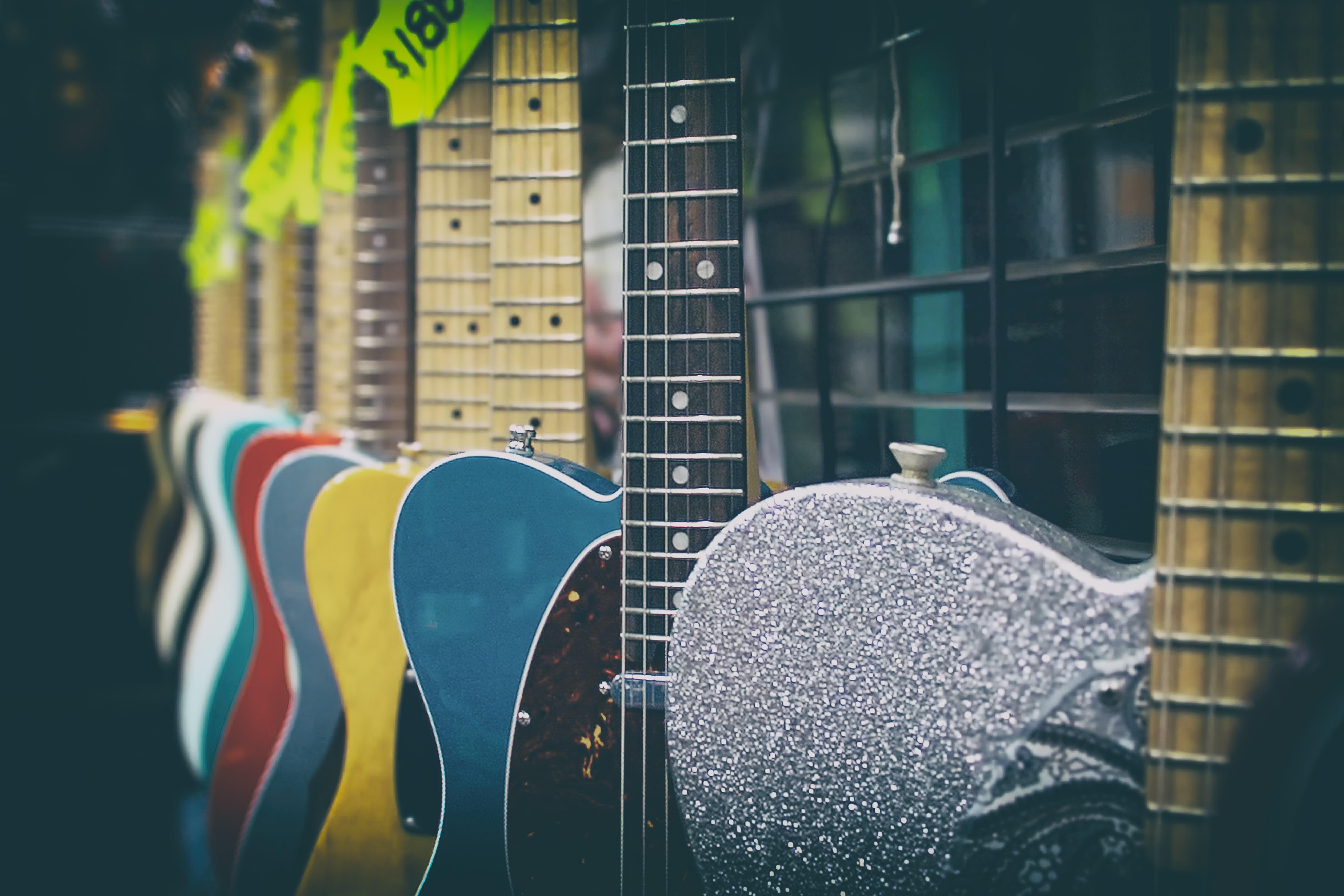 electric guitars for sale in various colors at a guitar shop, learn to play guitar electric