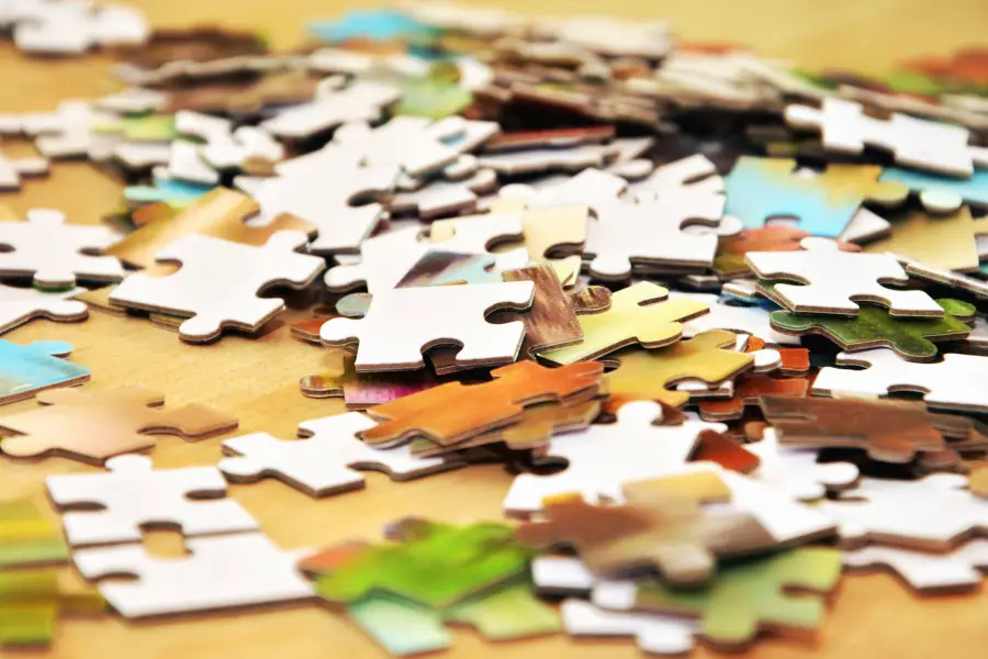 close up view of puzzle pieces scattered on table, brown photo overall