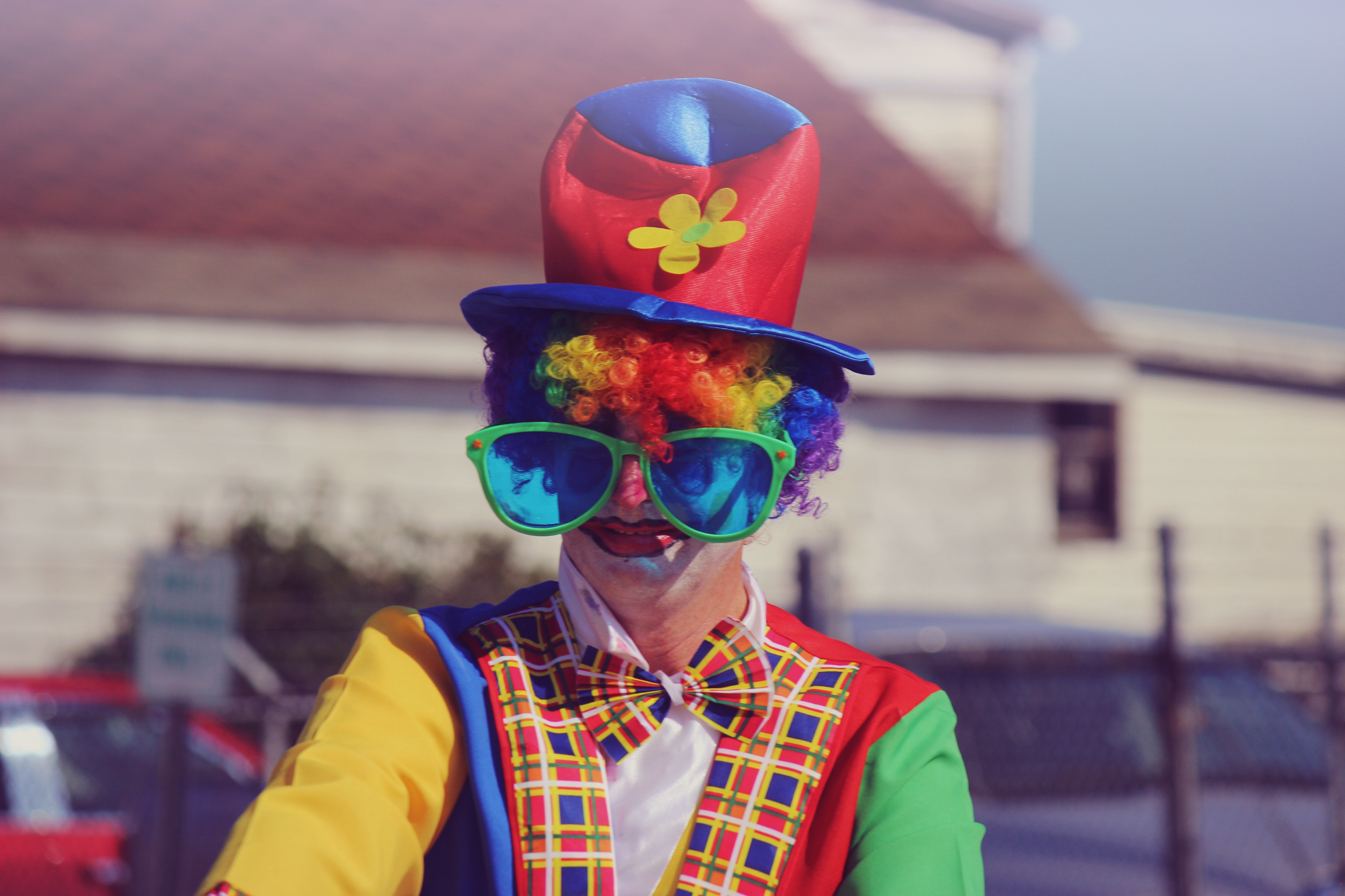 strange hobby of clowning, man in clown costume and large glasses