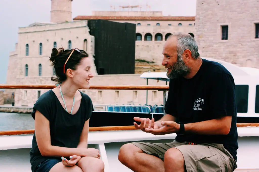 woman helping man learn a language on a boat