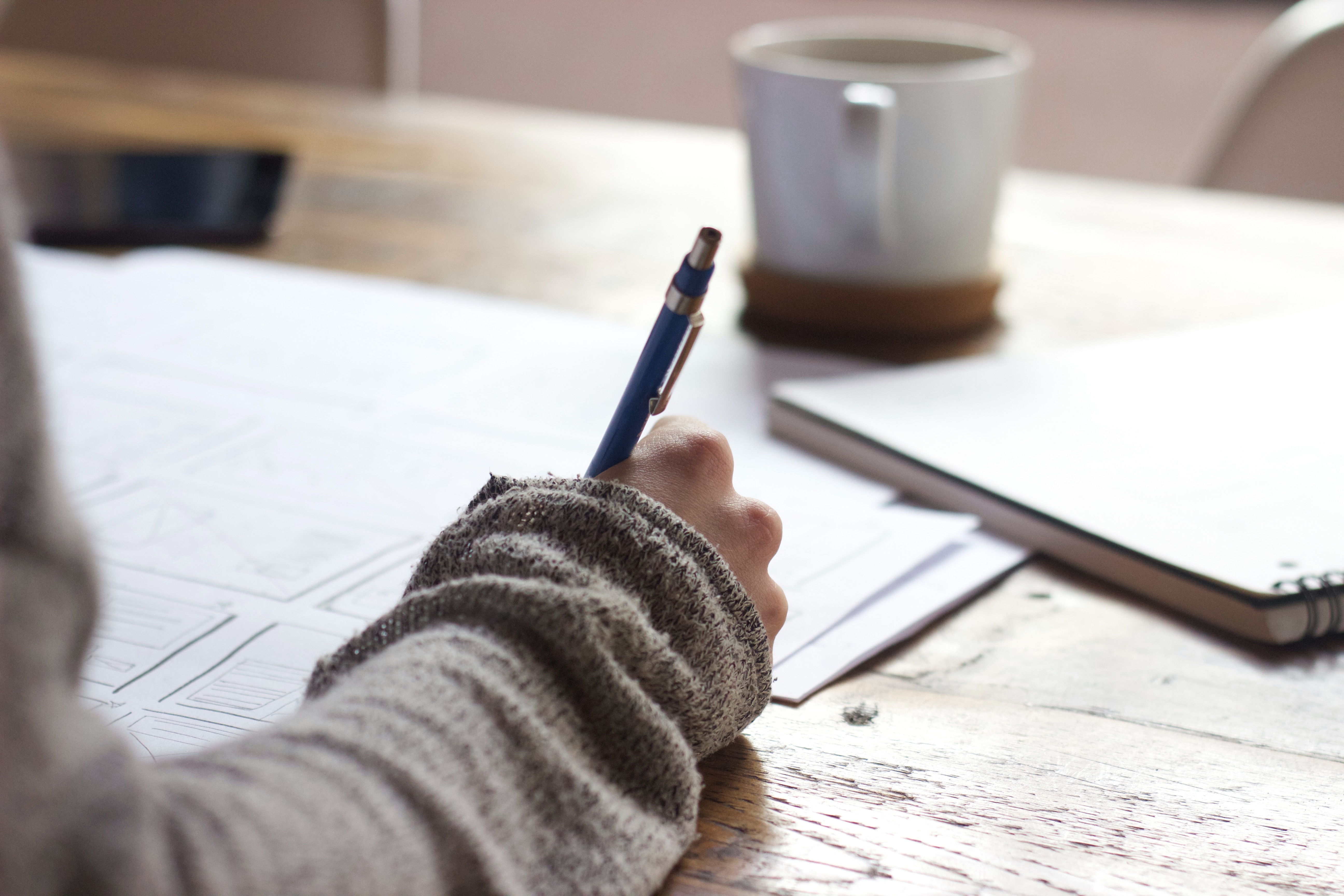 woman journaling on wooden coffee table