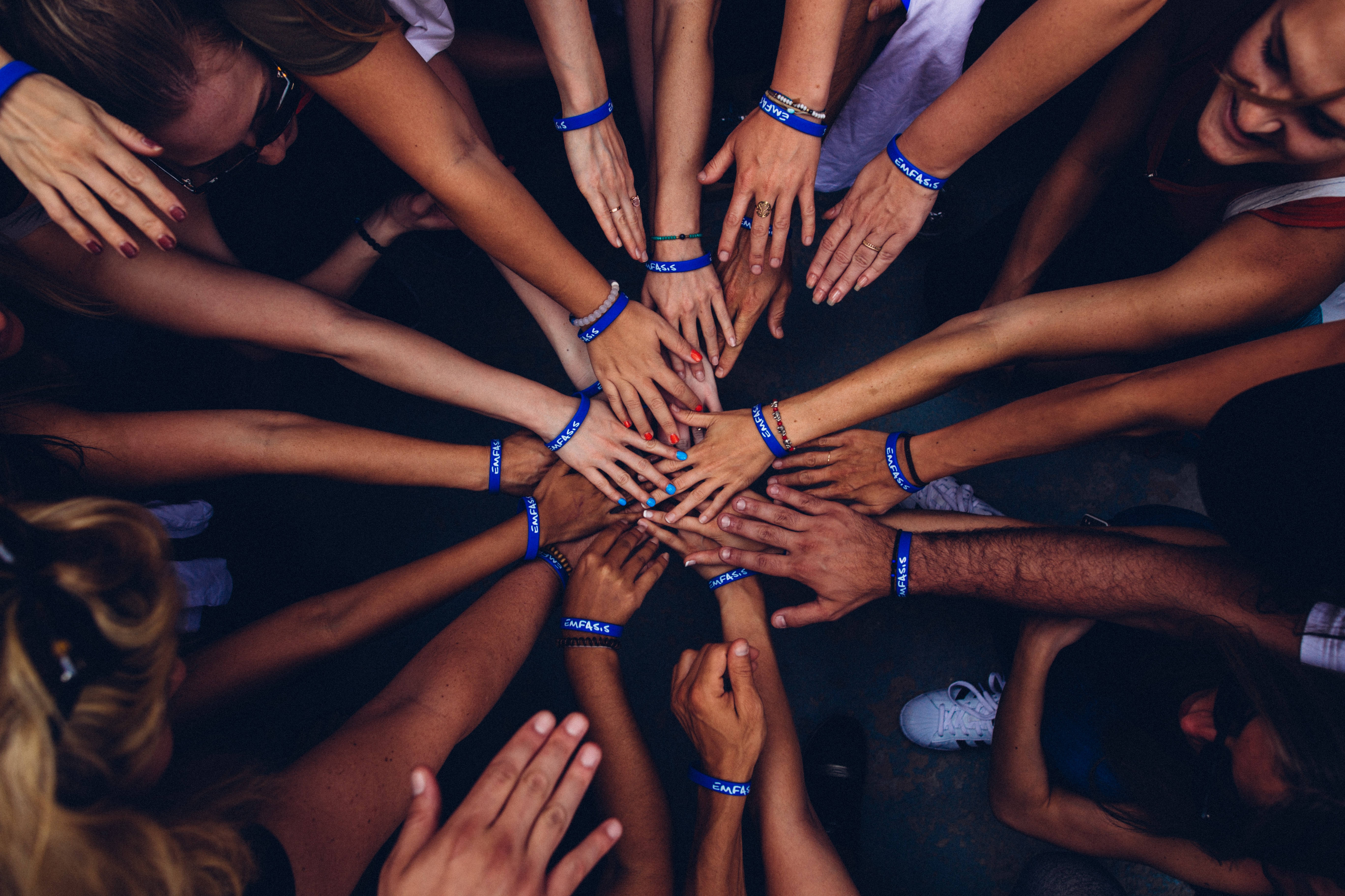 overview of volunteers hands in a circle 