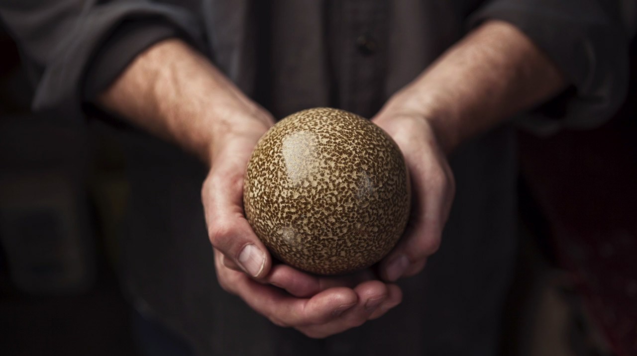 man holding perfect sphere ball of mud hikaru dorodango