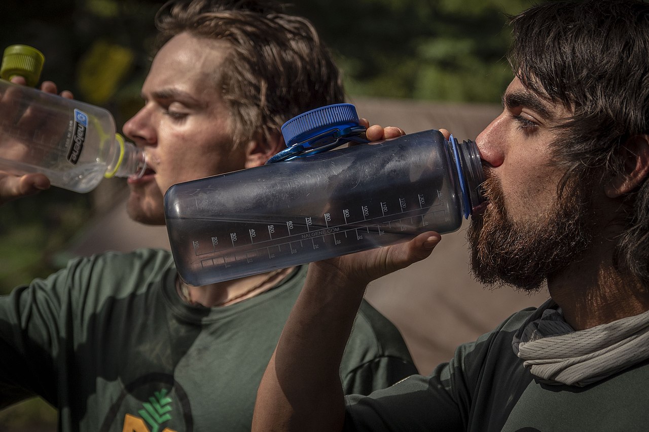 essential extra drinking water, two young men drinking from nalgene water bottles