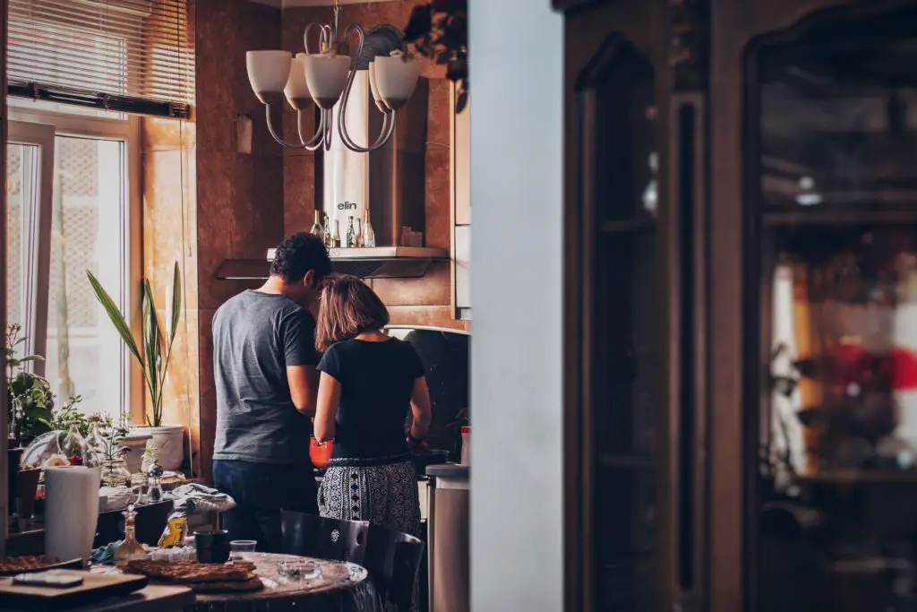 cooking hobby; couple standing near stove learning to cook