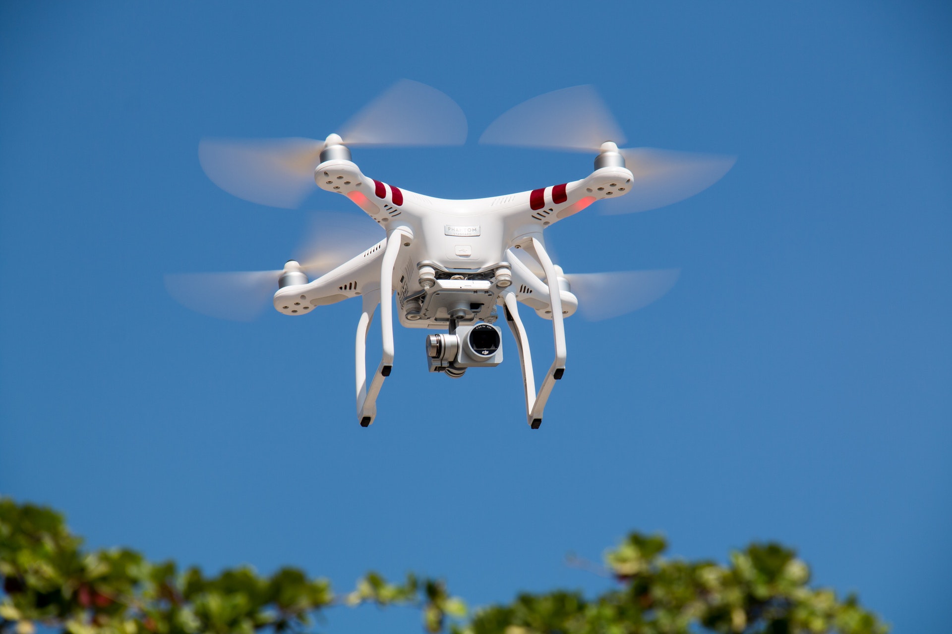 hobby drone flying, white drone against blue sky