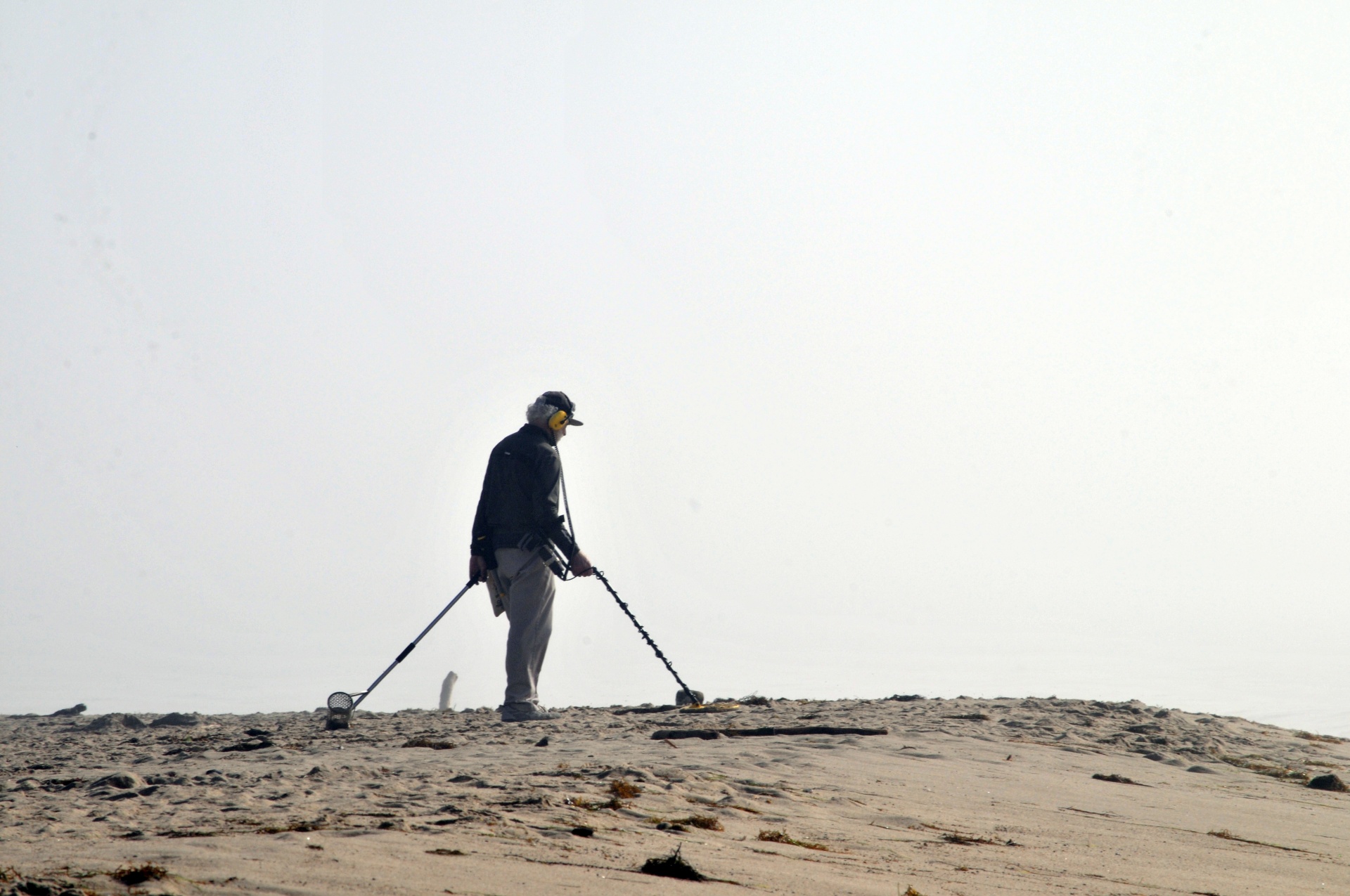 man on beach with metal detector