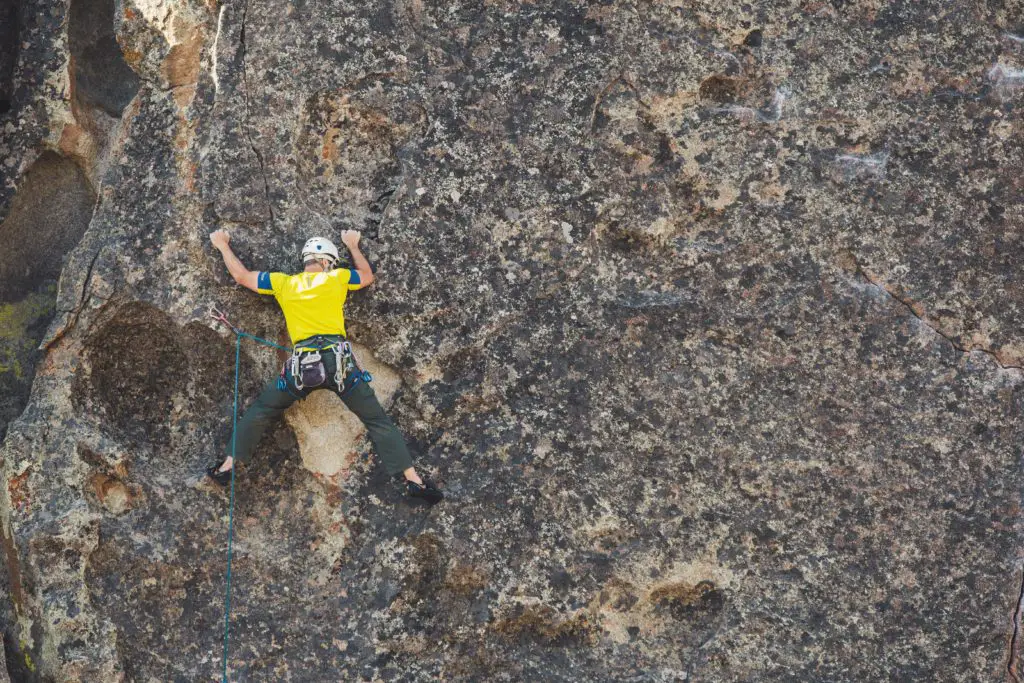 man sport climbing on rock face