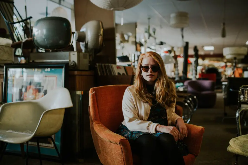 woman sitting in a chair at a thrift store