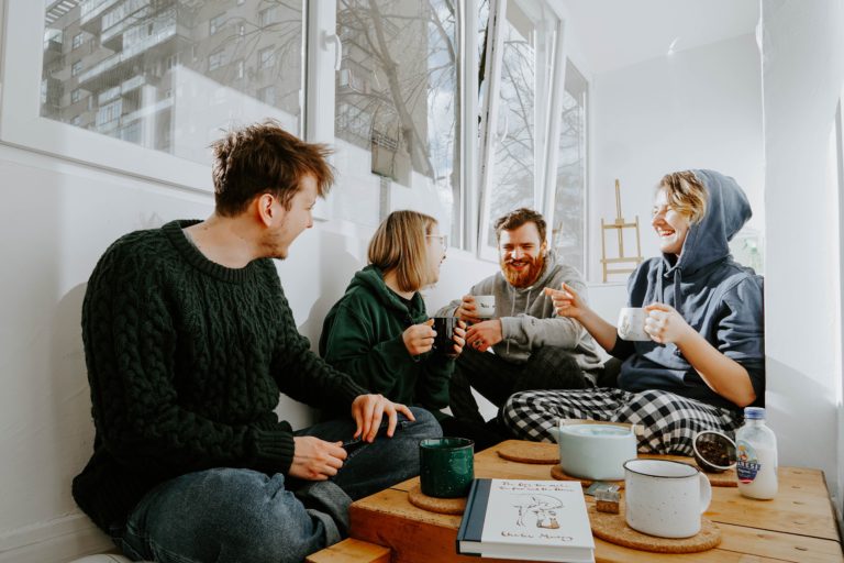 group of young extrovert adults sitting and drinking tea