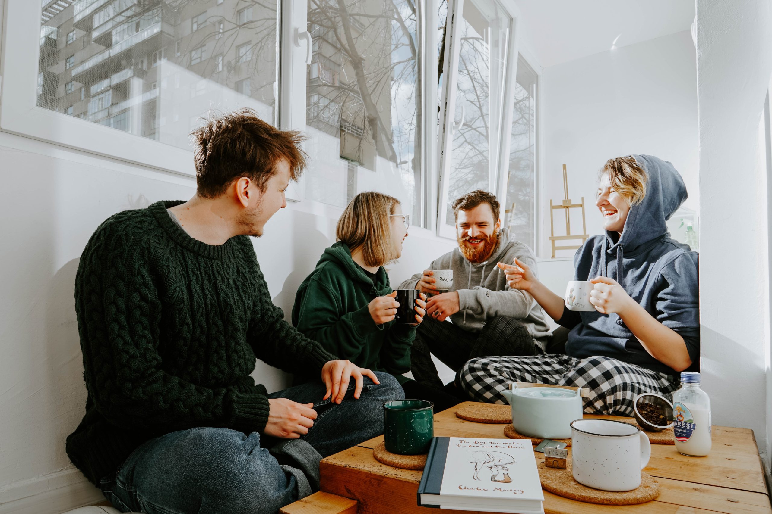 group of young extrovert adults sitting and drinking tea