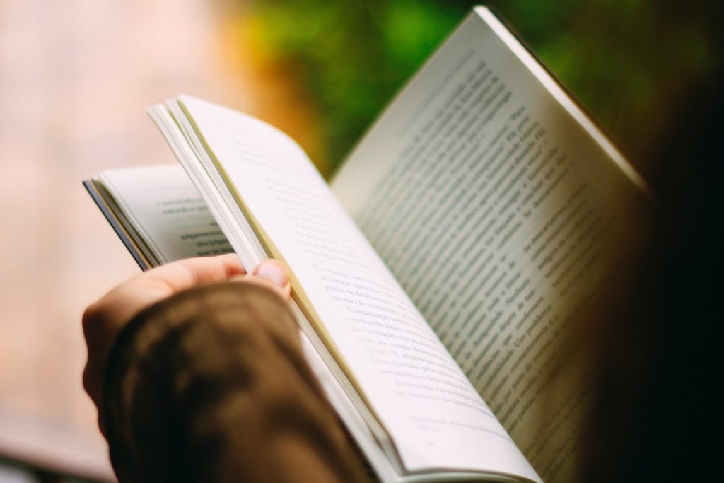 close up view of woman holding an open book