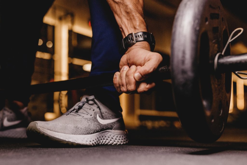 man about to dead-lift weights; home hobbies working out