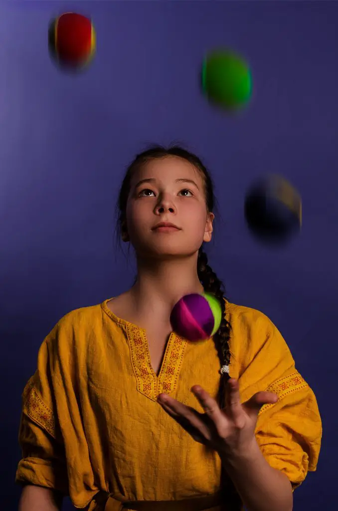 girl juggling against purple background; home hobby