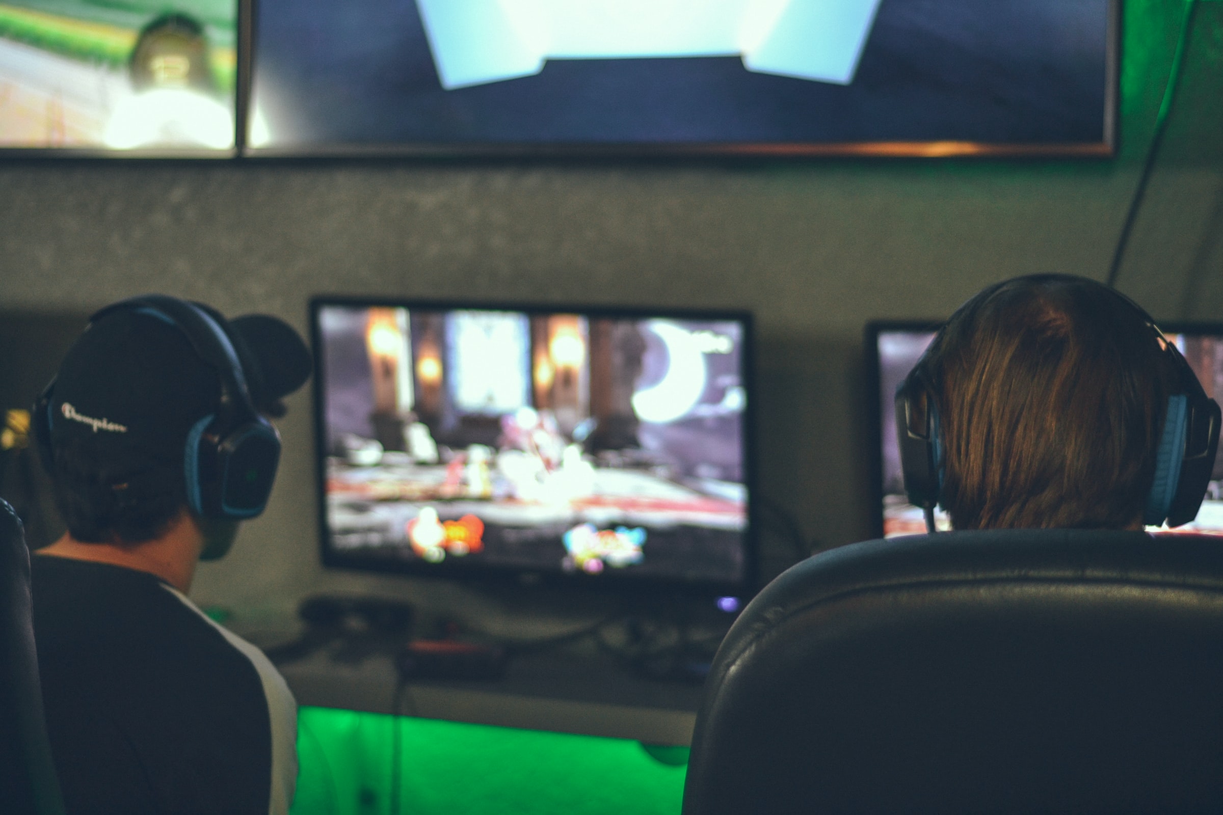 two men playing video games, looking at computer screen