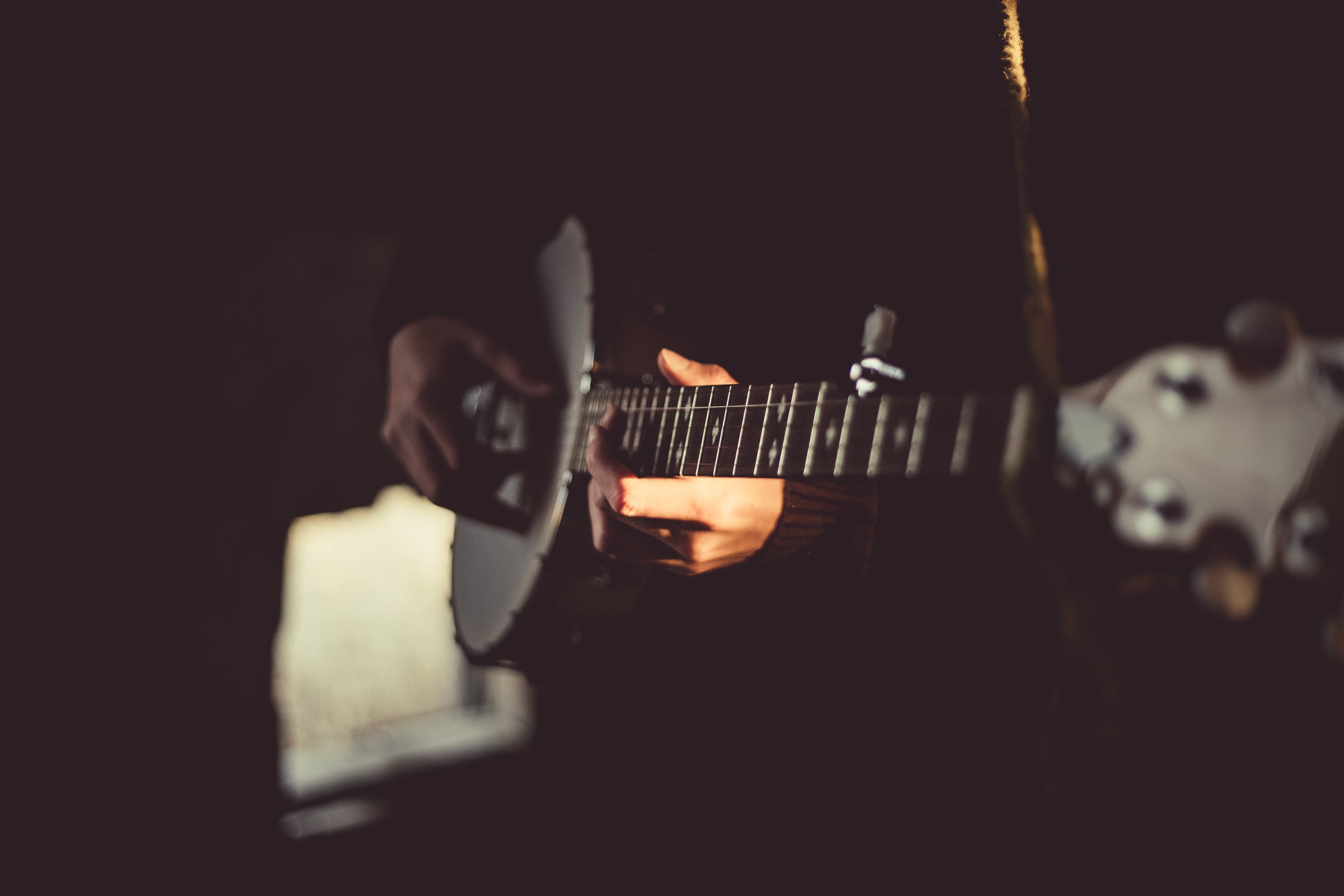 close up view of hands playing the banjo; music and instruments are a great hobby to cope with stress and anxiety