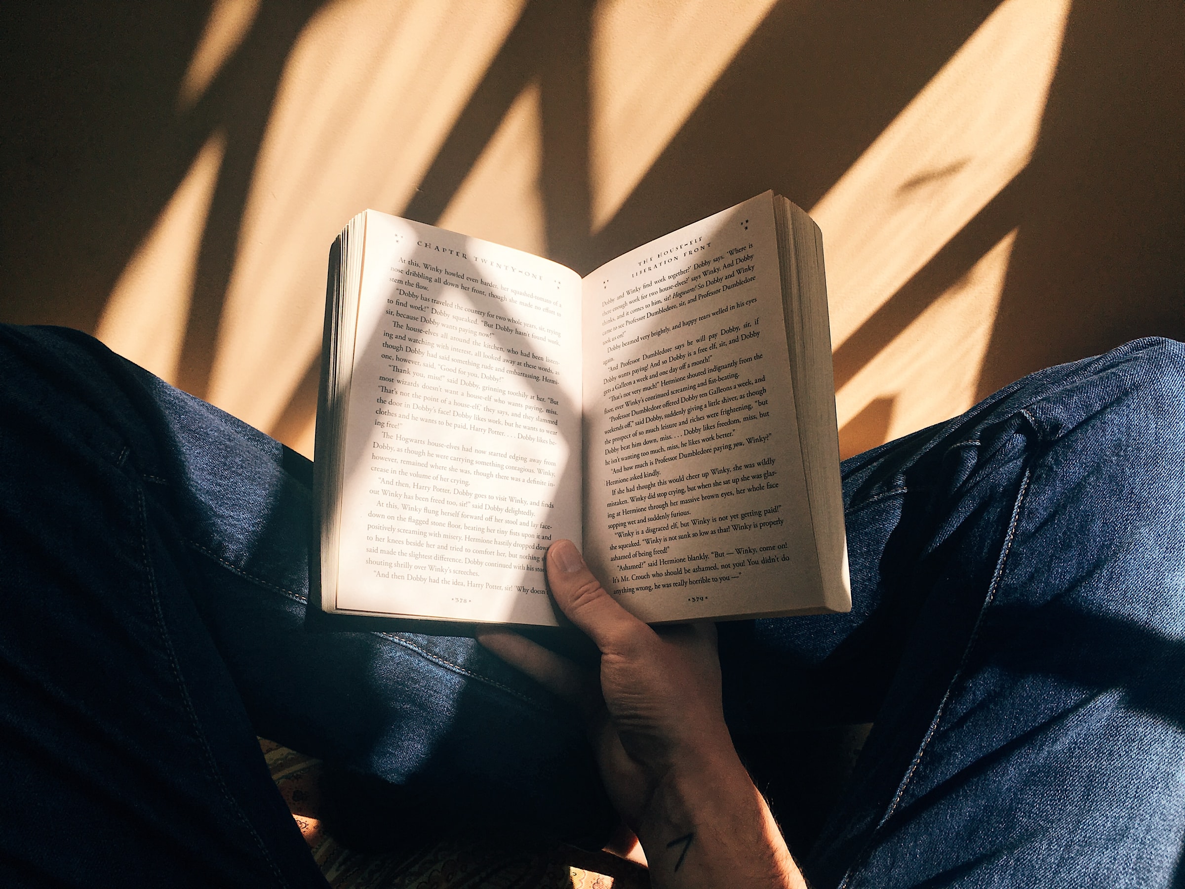 legs crossed with open book close up, reading as a hobby to cope with stress and anxiety