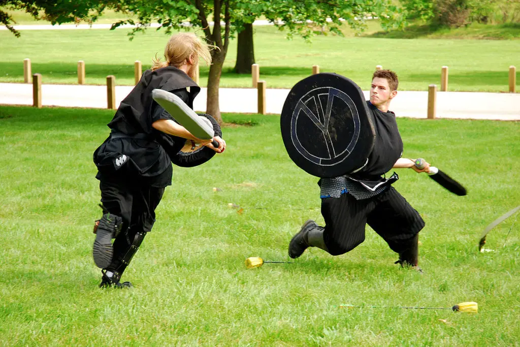 Two men in combat position while LARPing outdoors