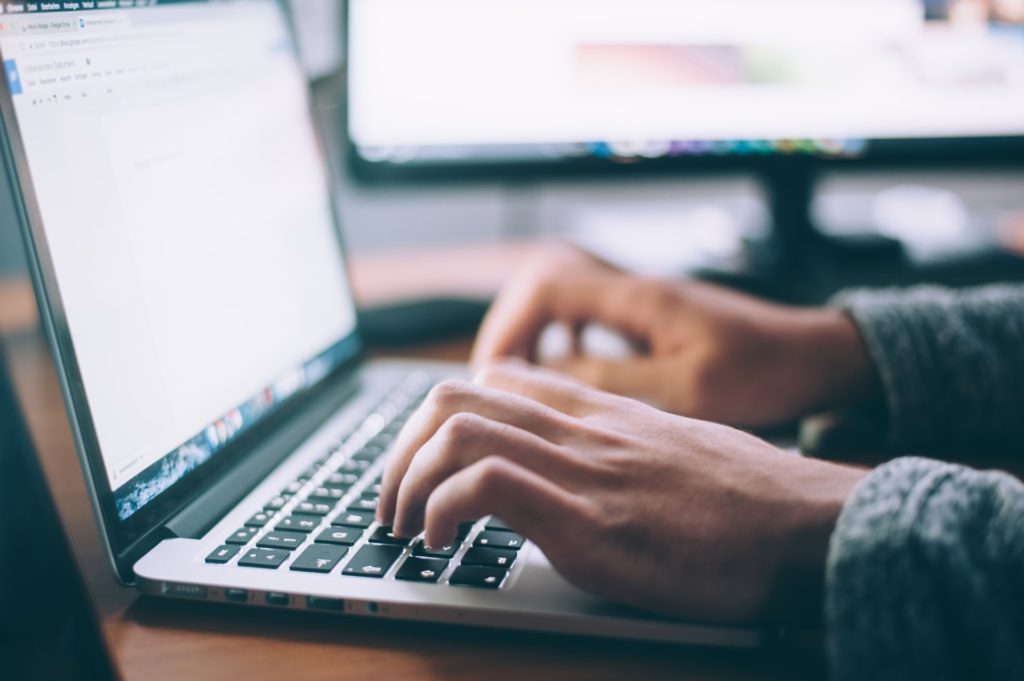 Close-up image of hands typing on a keyboard