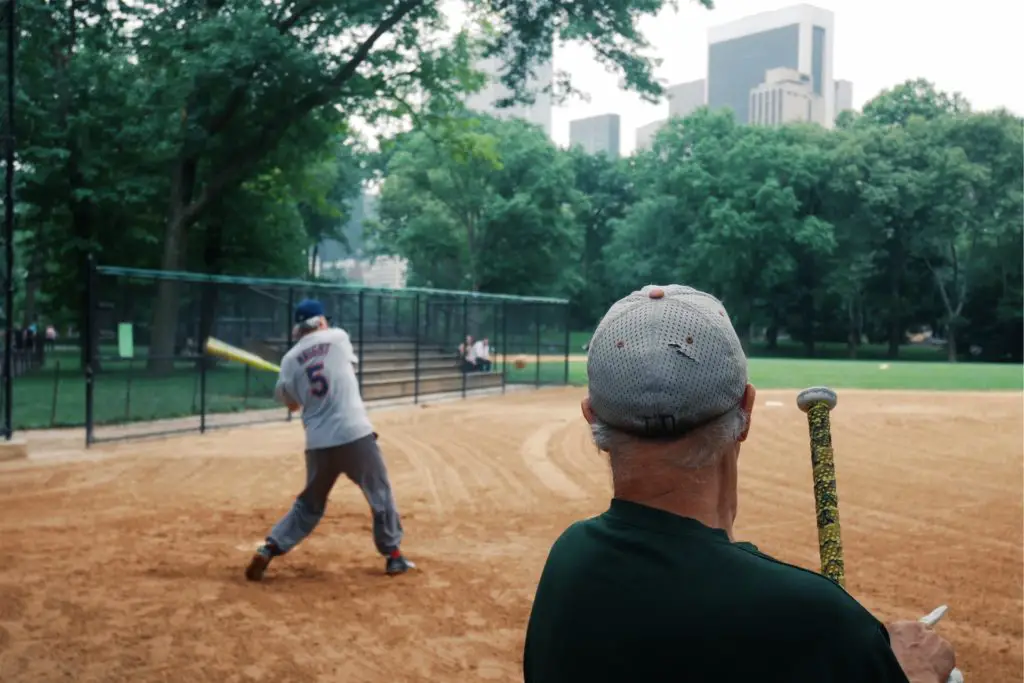 hobbies for weight loss include joining an adult sports league.  Pictured are two senior men in a baseball field, one at bat swinging with the other watching