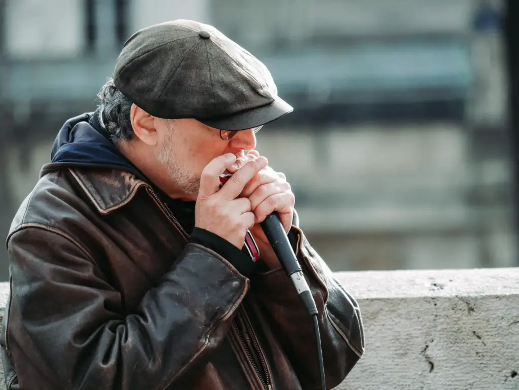 hobbies for stay-at-home dads include learning the harmonica.  Man holding harmonica and microphone