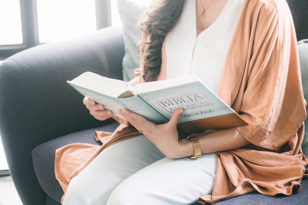 view of womans hands holding a book open reading