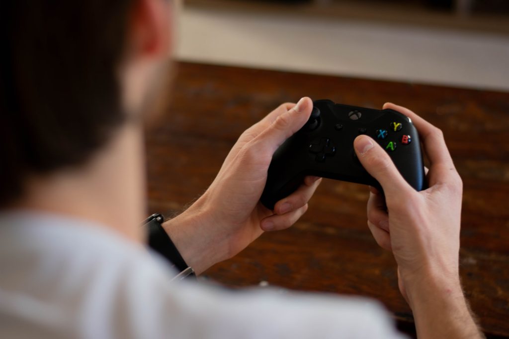 man holding video game remote; video game hobby to improve hand-eye coordination