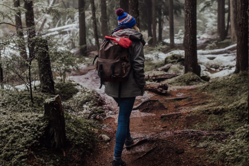 outdoor winter hobby hiking, woman hiking with light snowfall