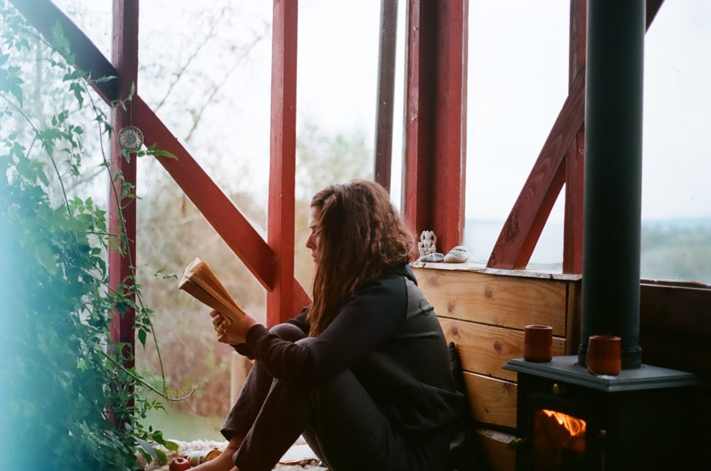 woman sitting on the floor reading a book; hobbies for learning