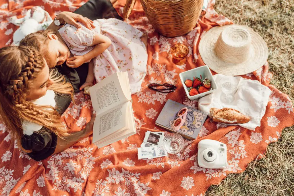 overhead view of mother and daughter having a picnic reading a book