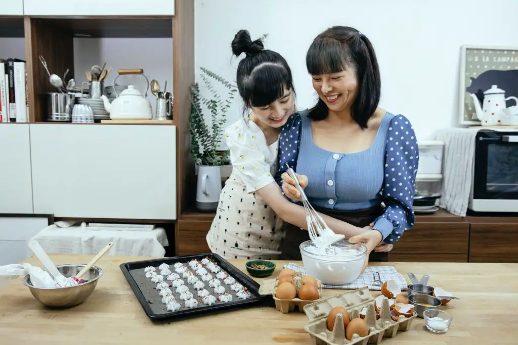 mother and daughter baking in the kitchen; baking hobby