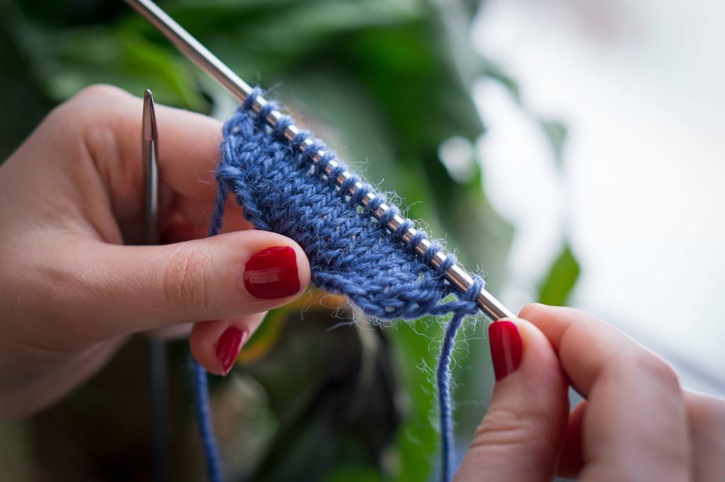 close up view of hands knitting