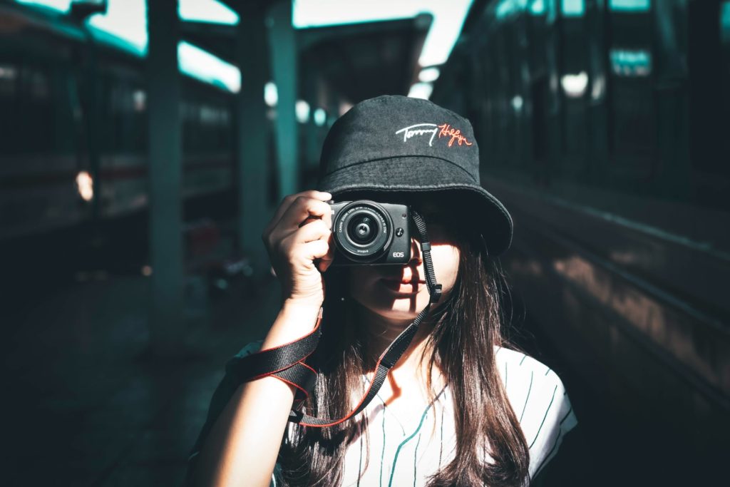 straight ahead view of woman holding camera up to her eye