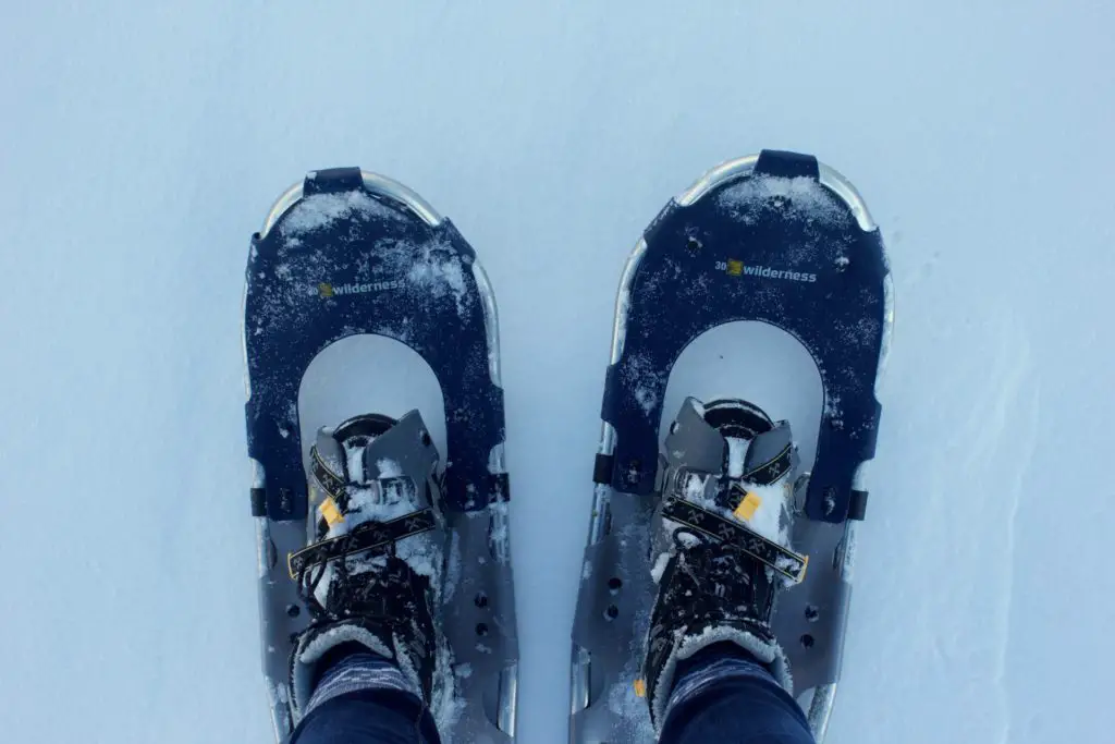 view of feet in snowshoes against snowy ground