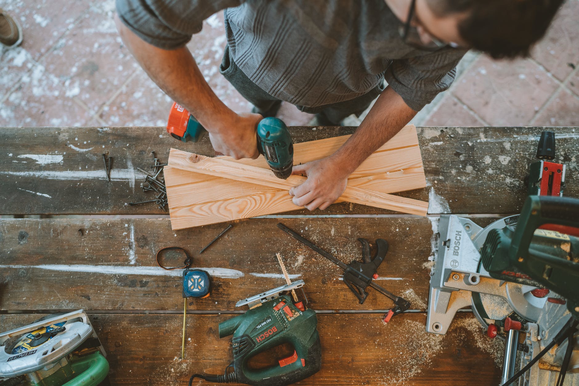 a man drilling hole on a wood