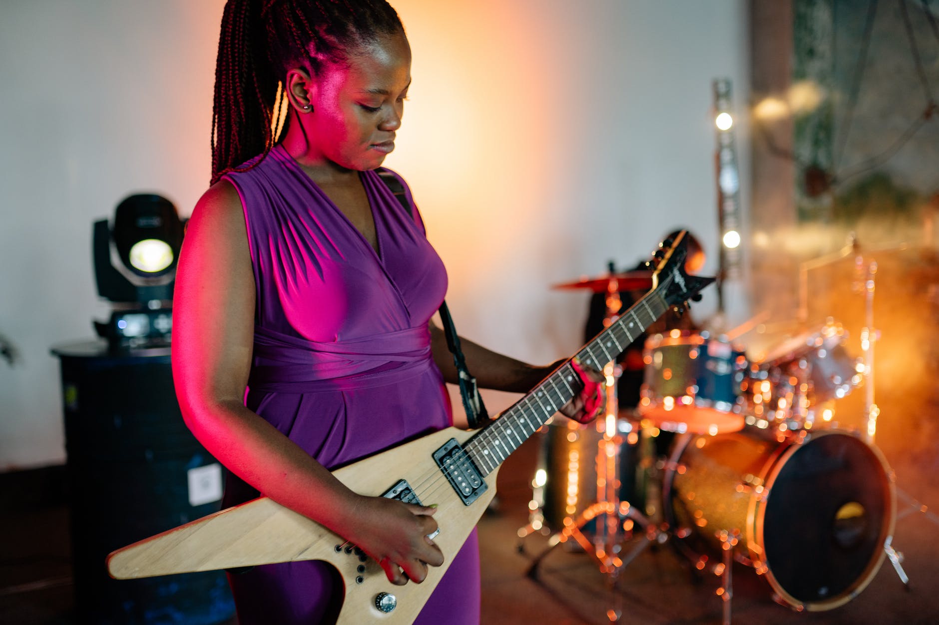 man in purple tank top playing electric guitar