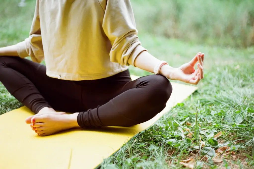 woman sitting on a yoga mat outdoors