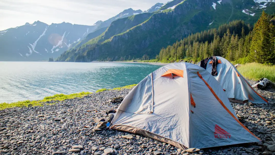 camping along the river, view of tents with mountains in the background