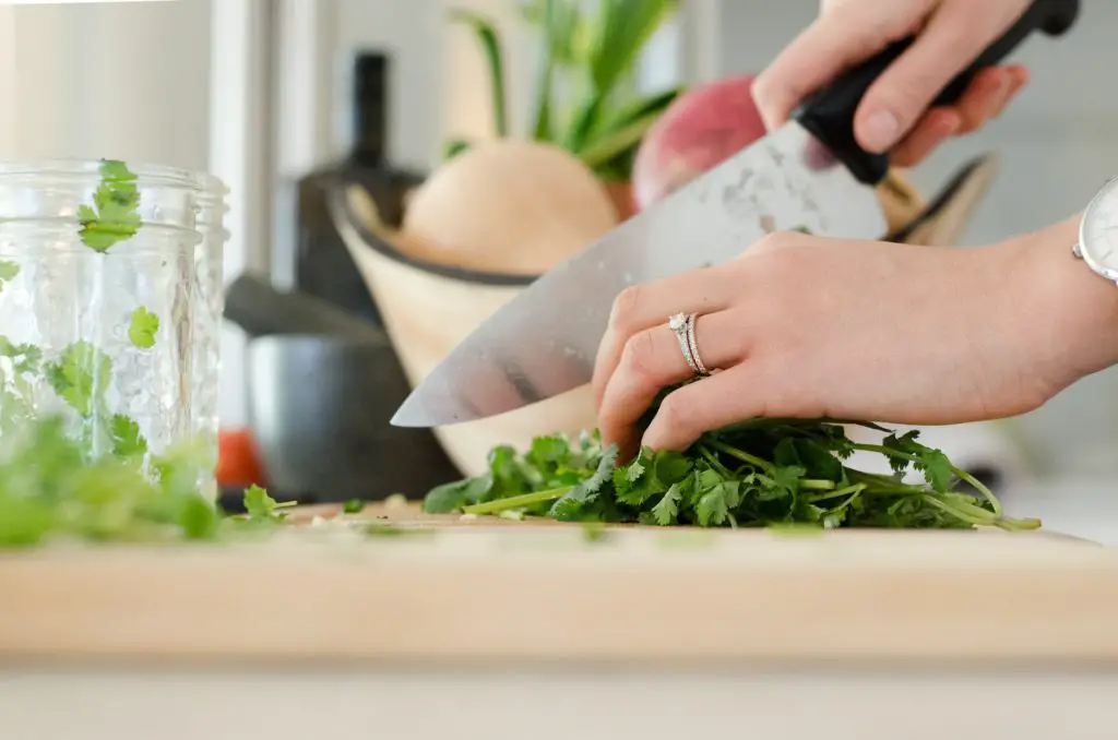 close up of hands chopping vegetables 