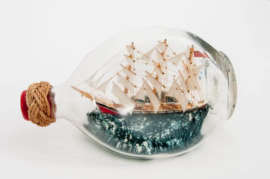 close up image of a ship in a bottle against white background