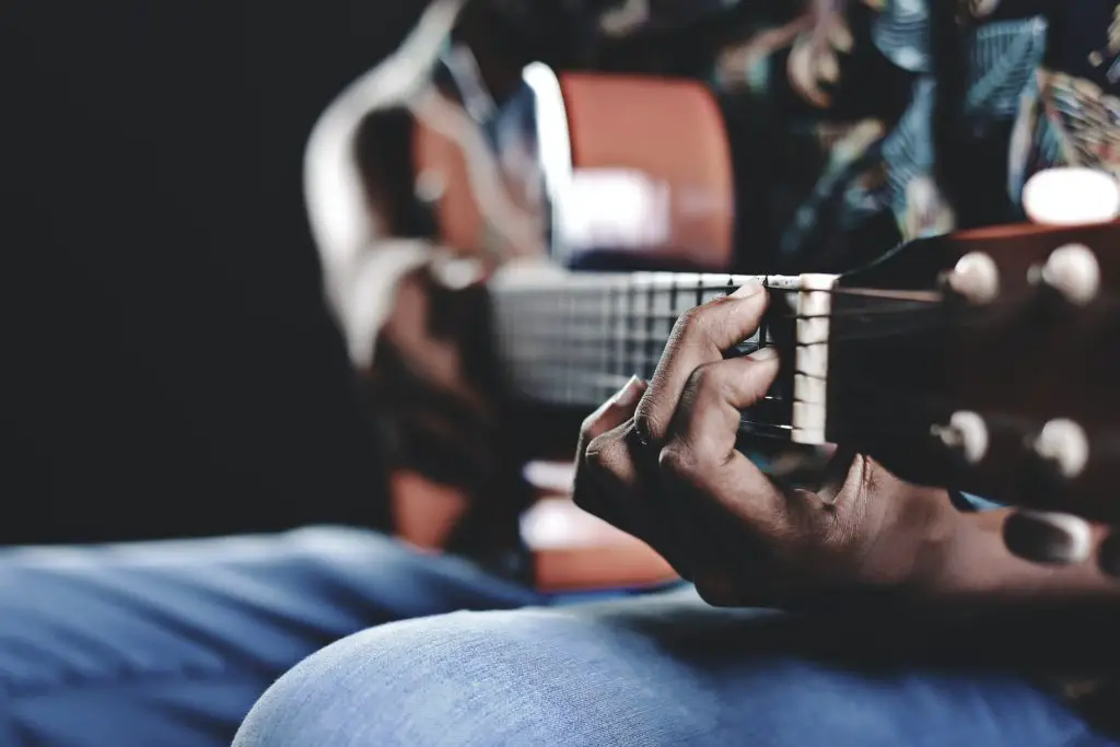 close up of man playing guitar