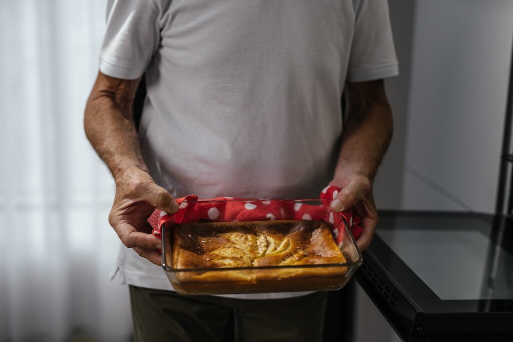 man holding pan of freshly baked bread, baking hobby close up