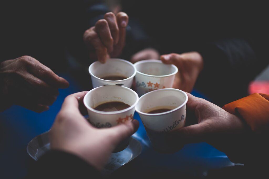 friends cheering their paper coffee cups, coffee hobby and quotes