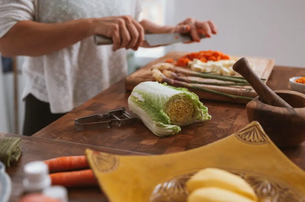 woman chopping vegetables on cutting board