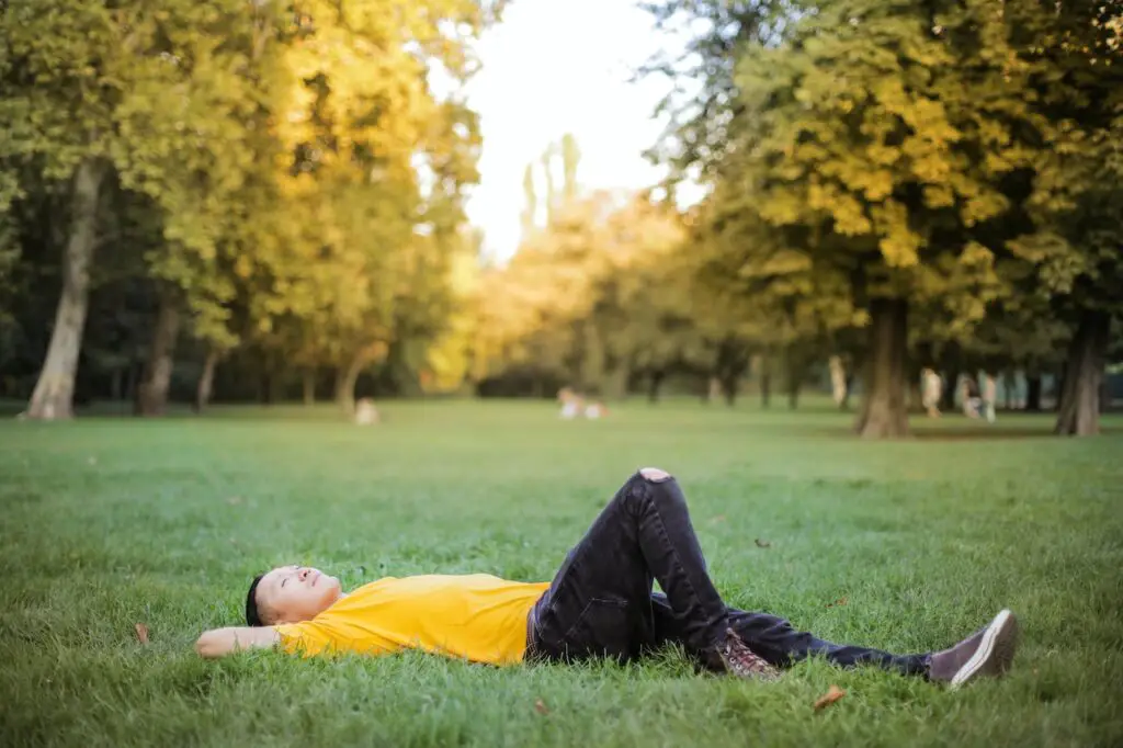find a new hobby by considering your interests, man lying in field looking at sky