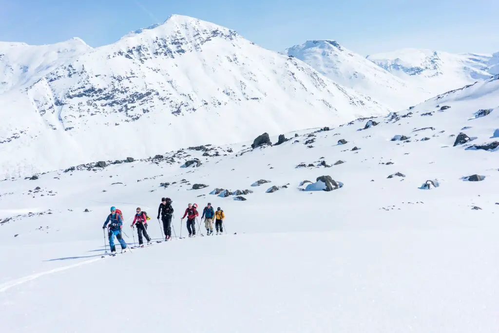 group of 6 skiiers walker in a white alpine snowy mountain area