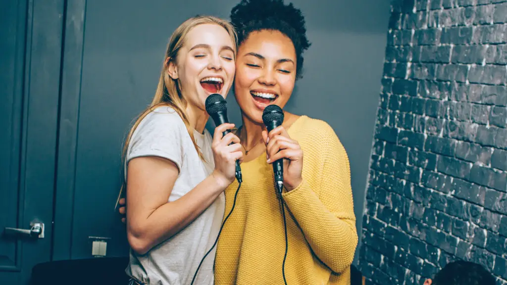 two young women singing karaoke 