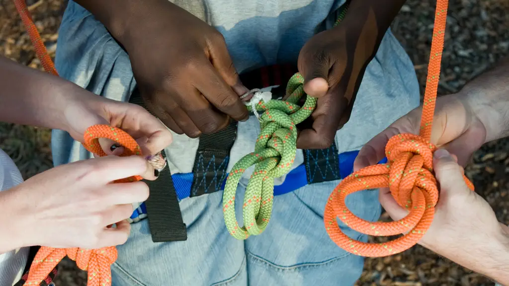 group of hands tying knots for rock climbing