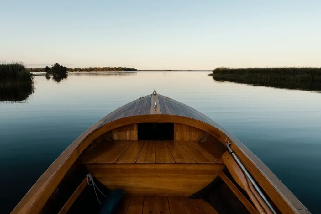 view from a wooden boat on a still lake at sunset