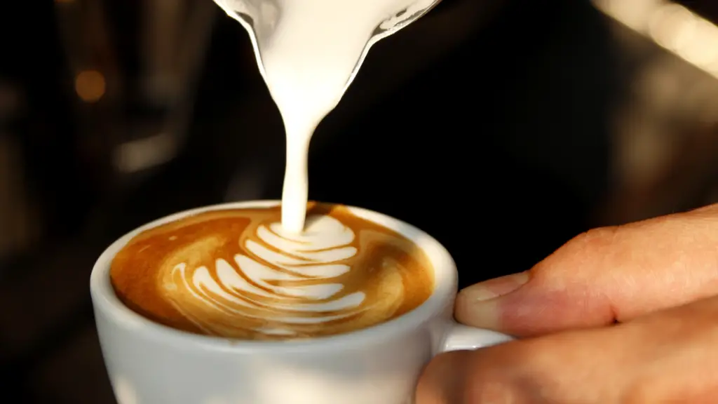 close up of hands pouring latte art; coffee hobby